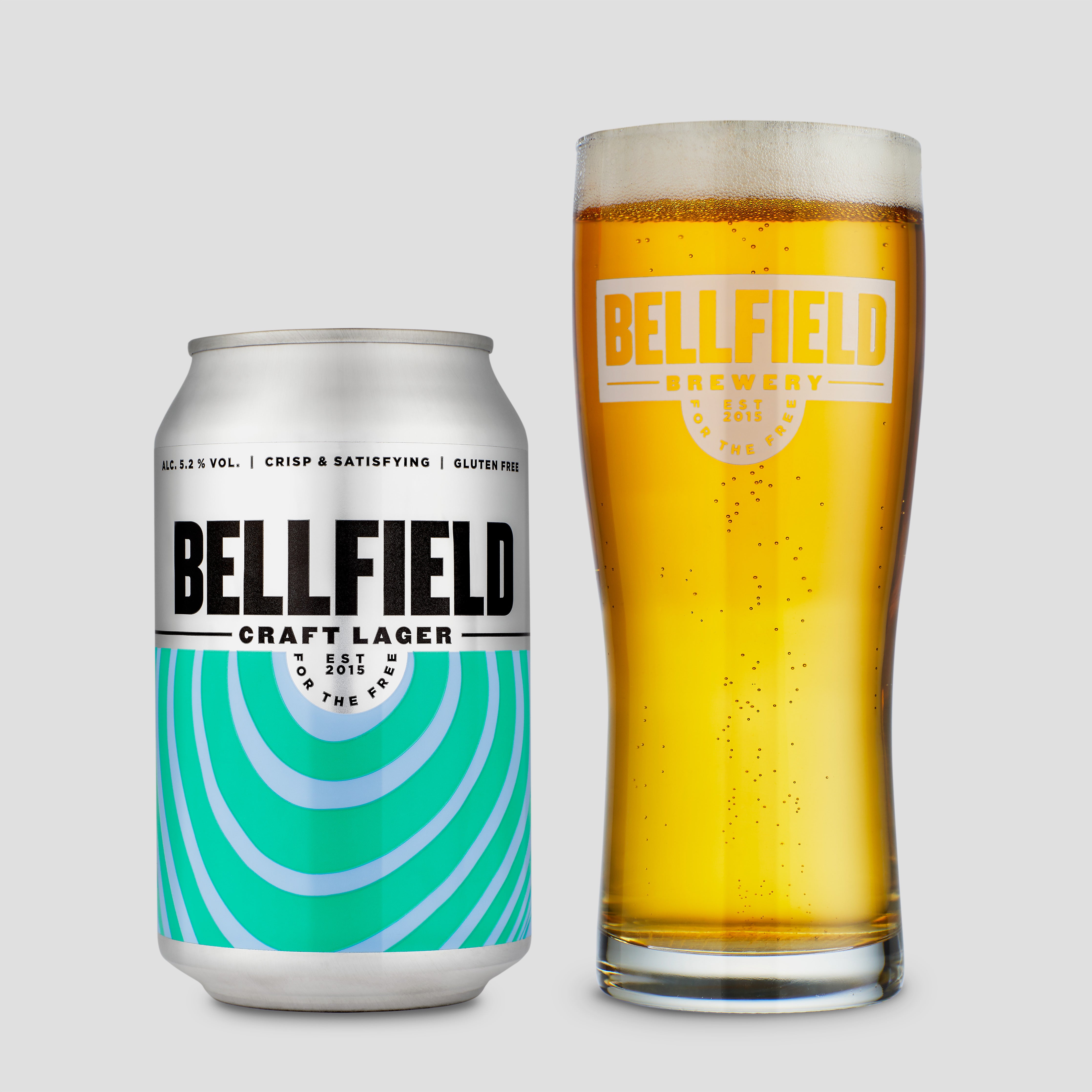 A 330ml can of crisp and satisfying Craft Lager next to a half pint glass of beer.