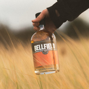 70cl bottle of Single Malt Scotch Whisky in a field of barley.
